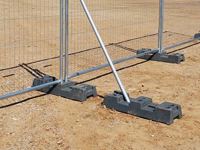 A steel temporary fence bracing supports the temporary fence with a black rubber feet installed.